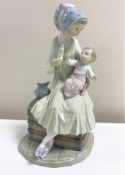 A Lladro figurine : Feeding her Baby, model 5140, height 23 cm, boxed.