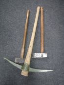 A pick axe together with an axe and sledge hammer