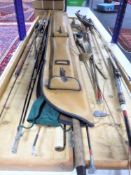 A large collection of fishing rods, reels, wooden storage case containing rods,
