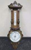 An early 20th century carved oak aneroid barometer