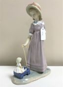 A Lladro figurine : Girl with Toy Wagon, model 5044, height 27 cm, boxed.