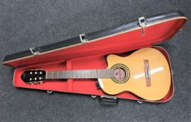 An Encore electric classical guitar in hard carry case CONDITION REPORT: No lead.
