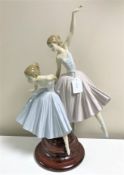 A Lladro figurine : Merry Ballet, model 5035, on wooden plinth, overall height 50 cm, boxed.