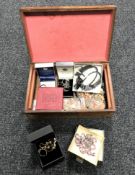 A wooden jewellery box containing costume jewellery.