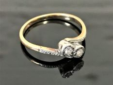 An 18ct gold and platinum set two stone diamond ring, size Q.