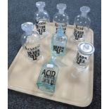 Seven glass chemist bottles with sign writing labels