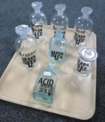 Seven glass chemist bottles with sign writing labels