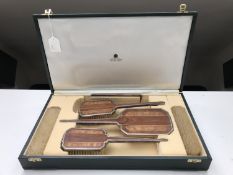 A six piece sterling silver and walnut backed dressing table brush set in a leather box retailed by