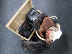 A wicker basket and wicker storage box containing assorted leather hand bags