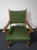 A blonde oak scroll arm armchair in green fabric