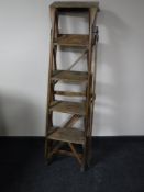 A folding set of wooden step ladders by Hatherley Lattistep