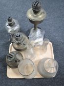 A tray of four vintage oil lamps, four glass chimneys,