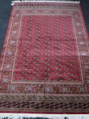 A Bokhara carpet on red ground, 2.3m x 1.