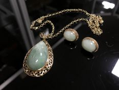 A jade pendant mounted in 9ct gold suspended upon a yellow metal chain with matching earrings.