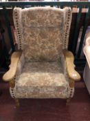 A blonde oak framed wing back armchair