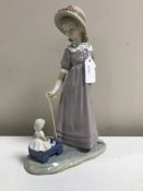 A Lladro figurine : Girl with Toy Wagon, model 5044, height 27 cm, boxed.