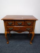 A reproduction mahogany low boy and a pair of lamp tables