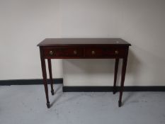 A reproduction mahogany two drawer side table