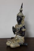 A bronze and mixed metal seated deity figure