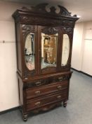 An Edwardian mirror doored press fitted with five drawers below,