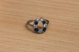 An antique platinum horseshoe ring, set with sapphires and old cut diamonds,