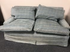 A two seater settee upholstered in checked loose covers