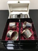 A pair of cased silver napkin rings together with two other pairs of napkin rings