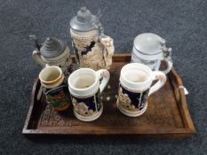 An Eastern carved serving tray together with a quantity of German pottery tankards and beer steins
