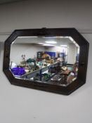 An early 20th century octagonal oak bevelled mirror