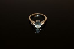 An 18ct white gold aquamarine and diamond ring, an oval-cut aquamarine within a claw setting,