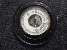 A circular carved oak barometer with enamelled dial