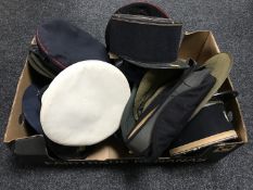 A box of a collection of military caps and berets