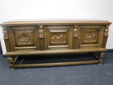 A 20th century continental carved oak triple door sideboard