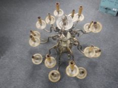 An early 20th century heavy brass sixteen branch chandelier