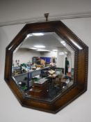 An early 20th century octagonal oak bevelled mirror