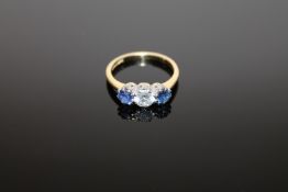 An 18ct gold three stone sapphire and diamond ring, the central stone weighing approximately 0.