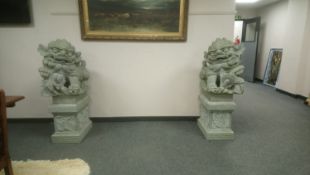 An impressive pair of Chinese carved granite temple dogs, on plinths, height 128 cm.