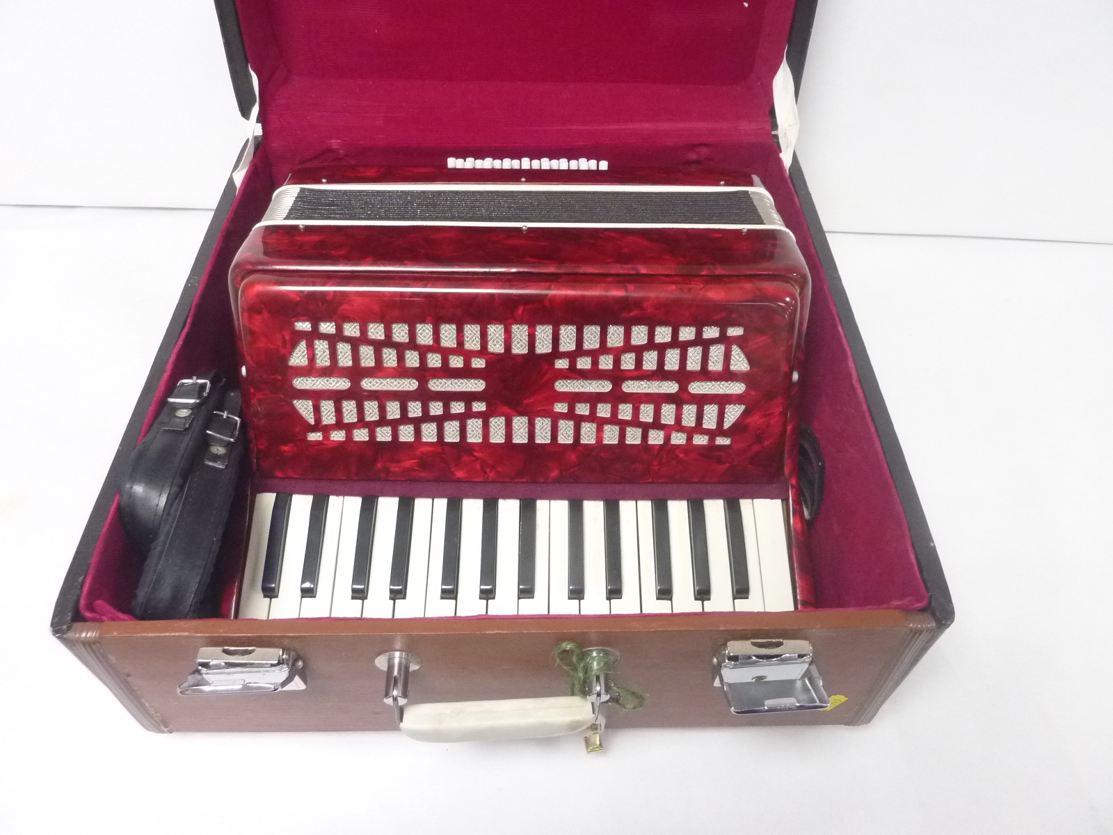 Piano accordion in marbled red, unbranded, in carry case.