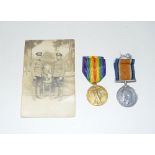 A WW1 medal pair named to G-12060 Private FA Elliott of the Middlesex Regiment with a photo postcard