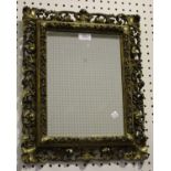 A late 19th century Florentine framed wall mirror, the rectangular plate within a carved and foliate