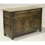 An 18th century oak dresser base, the moulded top above two frieze drawers and a pair of arched