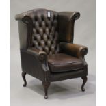 A late 20th century brown leather wing back armchair with studwork decoration, on cabriole legs,