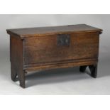 A mid-17th century oak six plank coffer, the edges with chip carving, the lid retaining original