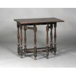 A 17th century oak gateleg table, fitted with a single fall flap, raised on turned baluster and