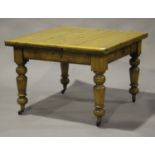 An Edwardian pine draw-leaf kitchen table, raised on ring turned legs and china castors, height