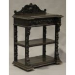 A late Victorian oak three-tier buffet with carved masks and foliate scrolls, on block supports,