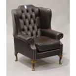 A late 20th century brown leather wing back armchair with studwork decoration, on cabriole legs,