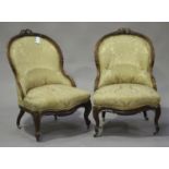 A pair of early 20th century French walnut showframe salon chairs with carved ribbon backs,