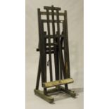 A late 19th/early 20th century oak and stained pine artist's easel, bearing applied plaque marked '