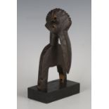 A Senufo carved hardwood heddle pulley, Ivory Coast, modelled as the head of a hornbill with